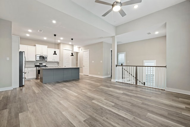 1220 Sloane Manor Trce, Houston, TX 77043 - kitchen featuring light wood-style flooring, stainless steel appliances, a ceiling fan, open floor plan, and white cabinetry