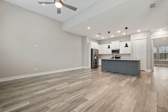 1220 Sloane Manor Trce, Houston, TX 77043 - kitchen featuring ceiling fan, stainless steel appliances, light wood finished floors, and white cabinetry