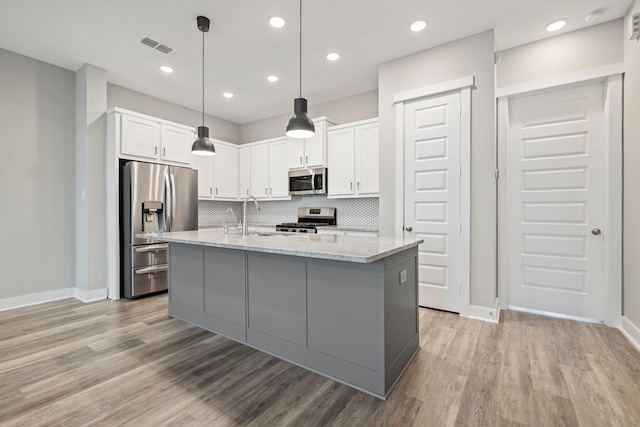 1220 Sloane Manor Trce, Houston, TX 77043 - kitchen featuring white cabinets, appliances with stainless steel finishes, light stone counters, a sink, and baseboards