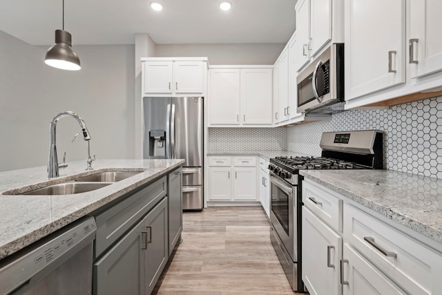 1220 Sloane Manor Trce, Houston, TX 77043 - kitchen featuring light stone counters, a sink, white cabinets, and stainless steel appliances