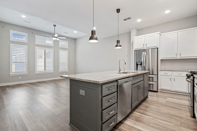 1220 Sloane Manor Trce, Houston, TX 77043 - kitchen featuring visible vents, light wood-style floors, a sink, appliances with stainless steel finishes, and gray cabinetry