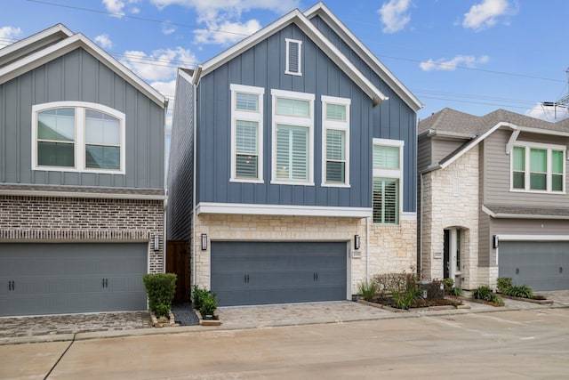 1220 Sloane Manor Trce, Houston, TX 77043 - view of front facade featuring board and batten siding, an attached garage, driveway, and stone siding