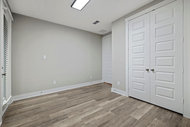 1220 Sloane Manor Trce, Houston, TX 77043 - unfurnished bedroom with baseboards, a closet, light wood finished floors, and visible vents