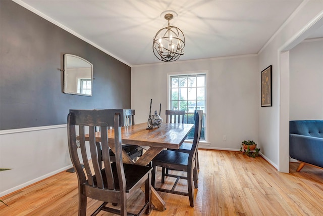 dining space with crown molding, baseboards, an inviting chandelier, and light wood-type flooring