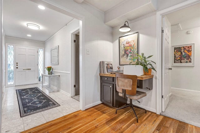 entryway featuring light wood-style floors, baseboards, and ornamental molding