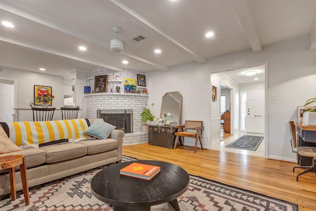 living room with beam ceiling, a fireplace, hardwood / wood-style floors, recessed lighting, and visible vents