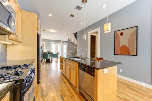 kitchen featuring a sink, stainless steel appliances, light wood-style flooring, and visible vents