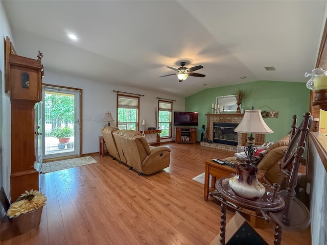 5325 County Road 2691, Buffalo, TX 75831 - living room featuring ceiling fan, light wood finished floors, a brick fireplace, lofted ceiling, and visible vents