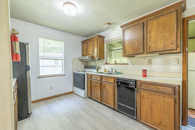 9847 N Lake Vw, Montgomery, TX 77316 - kitchen with white electric stove, dishwasher, a sink, light wood-style floors, and brown cabinetry