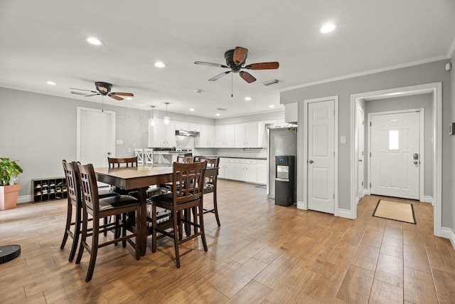 dining room featuring light wood-style flooring, a ceiling fan, recessed lighting, visible vents, and ornamental molding