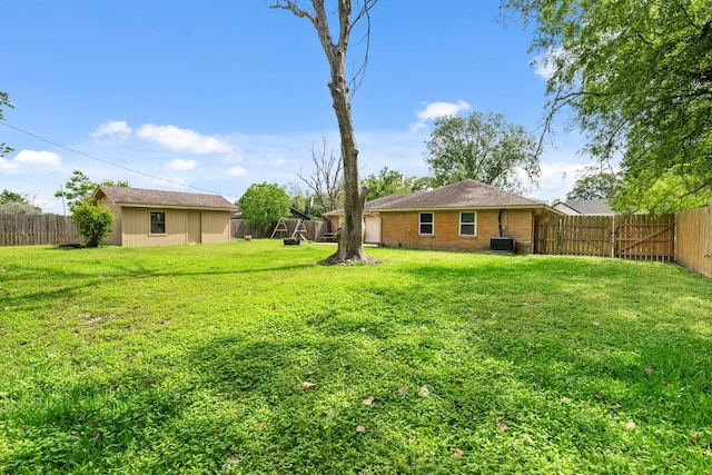 view of yard with a fenced backyard, central air condition unit, and an outdoor structure