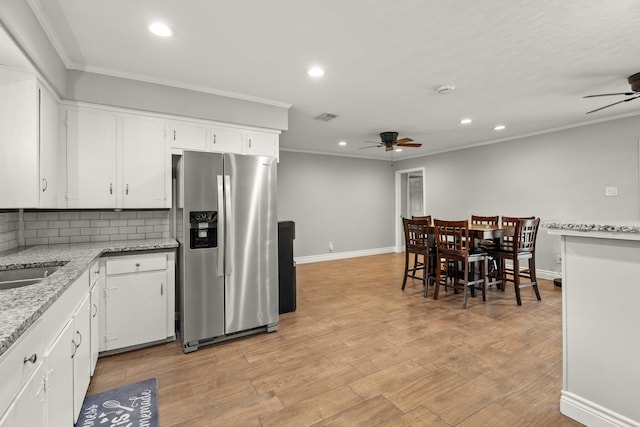 kitchen with ornamental molding, recessed lighting, white cabinets, stainless steel fridge with ice dispenser, and a ceiling fan