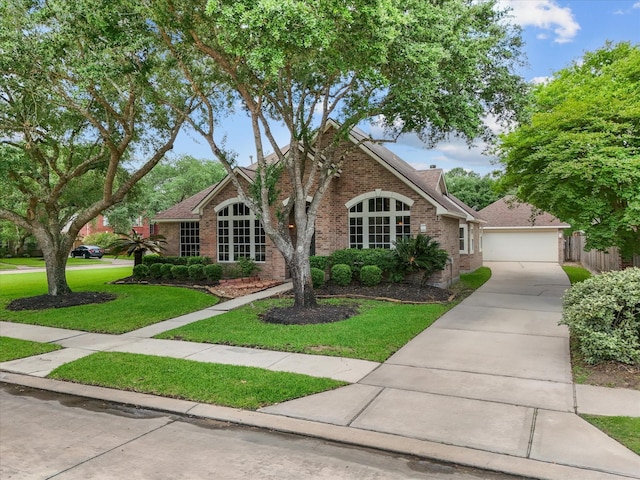 view of front of house with a detached garage, a front lawn, and brick siding