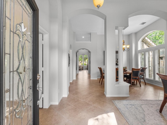 entrance foyer featuring visible vents, arched walkways, baseboards, and light tile patterned flooring