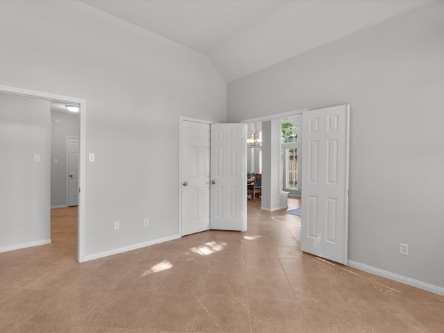 unfurnished bedroom with high vaulted ceiling, baseboards, light tile patterned flooring, and a chandelier