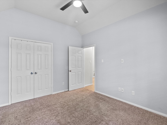unfurnished bedroom with carpet floors, baseboards, lofted ceiling, and a closet