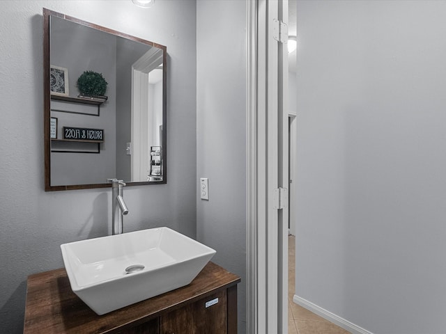 bathroom featuring baseboards, tile patterned flooring, and vanity