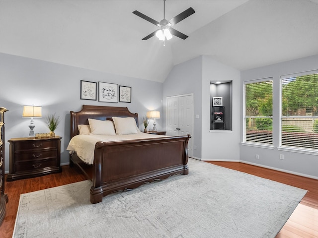 bedroom with wood finished floors, baseboards, ceiling fan, and lofted ceiling