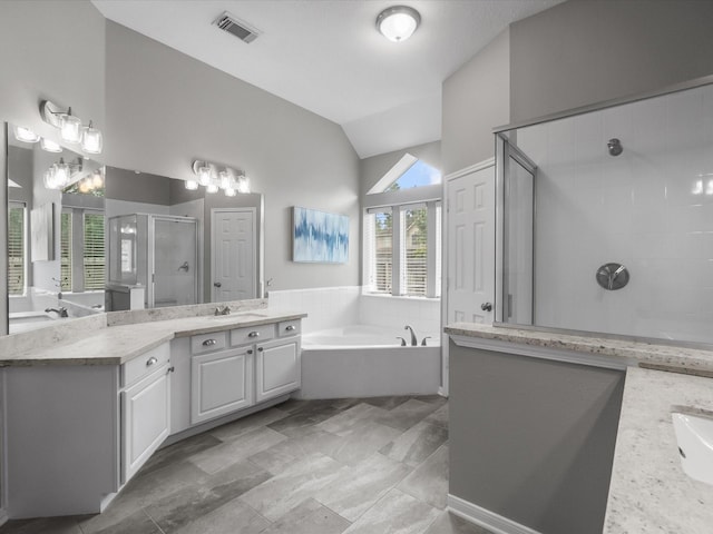 full bathroom featuring a garden tub, visible vents, a stall shower, a sink, and lofted ceiling