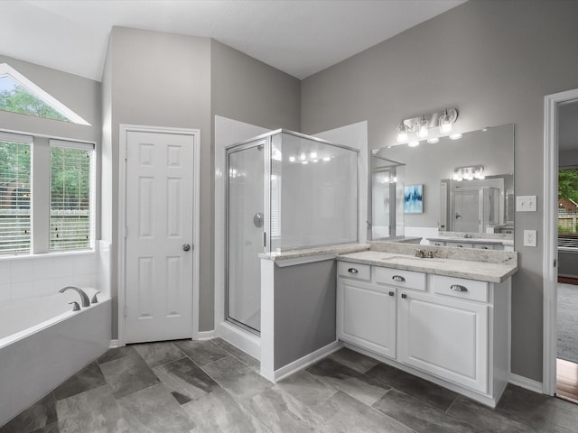 full bath with vanity, baseboards, a bath, and a stall shower