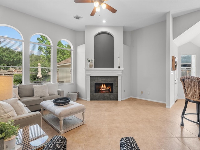living room with visible vents, a ceiling fan, plenty of natural light, and light tile patterned floors