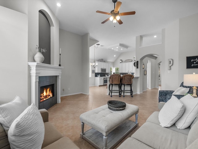 living room featuring arched walkways, a fireplace, ceiling fan with notable chandelier, lofted ceiling, and recessed lighting