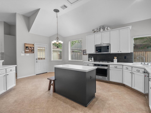 kitchen featuring an inviting chandelier, light countertops, white cabinetry, a sink, and appliances with stainless steel finishes