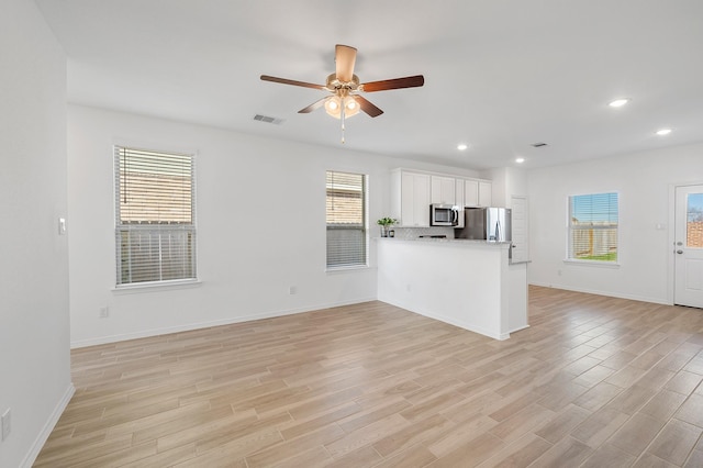 unfurnished living room with ceiling fan, light wood finished floors, recessed lighting, baseboards, and visible vents