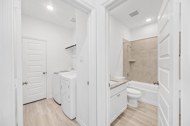 full bathroom featuring visible vents, vanity, washtub / shower combination, toilet, and separate washer and dryer