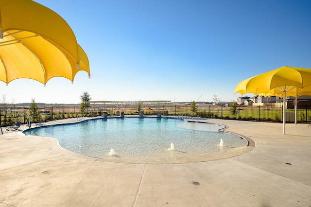 community pool with a patio and fence