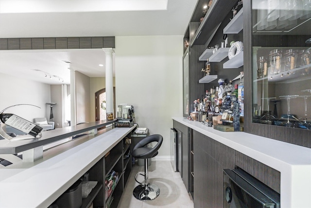 33519 Hillside Dr, Pinehurst, TX 77362 - indoor dry bar with light tile patterned floors, ornate columns, and baseboards