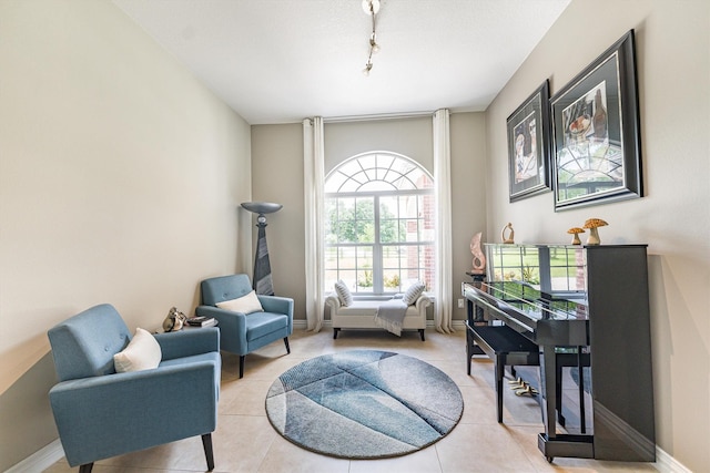 33519 Hillside Dr, Pinehurst, TX 77362 - sitting room featuring light tile patterned floors, rail lighting, and baseboards