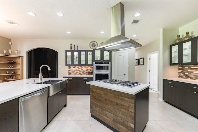 33519 Hillside Dr, Pinehurst, TX 77362 - kitchen featuring appliances with stainless steel finishes, island exhaust hood, tasteful backsplash, light tile patterned flooring, and recessed lighting