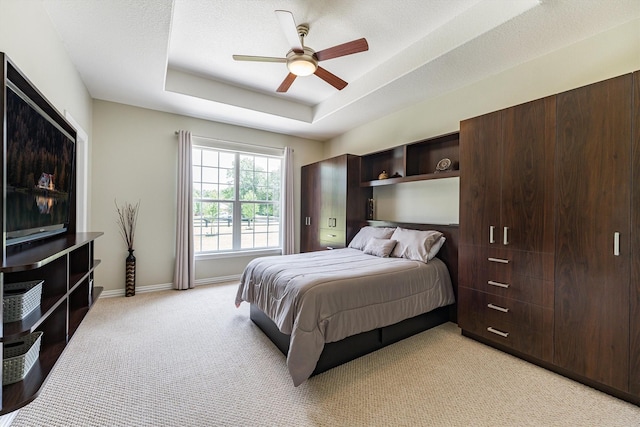 33519 Hillside Dr, Pinehurst, TX 77362 - bedroom with light carpet, a tray ceiling, baseboards, and a ceiling fan