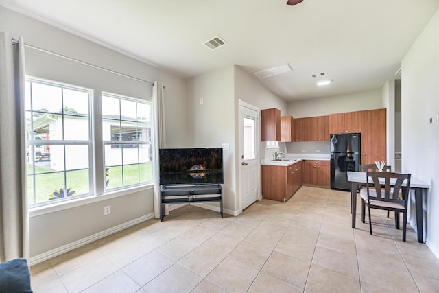 33519 Hillside Dr, Pinehurst, TX 77362 - kitchen with freestanding refrigerator, a sink, brown cabinetry, light countertops, and light tile patterned floors