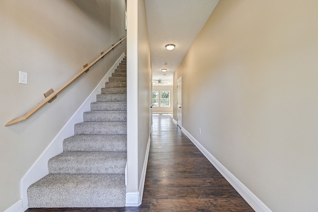 stairs featuring a ceiling fan, baseboards, and wood finished floors