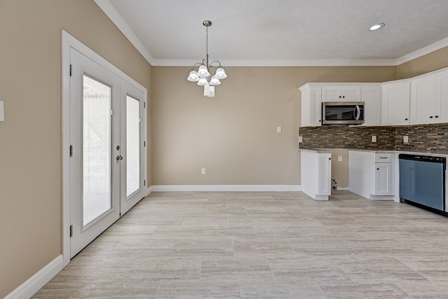 kitchen with stainless steel microwave, white cabinets, a chandelier, tasteful backsplash, and dishwasher