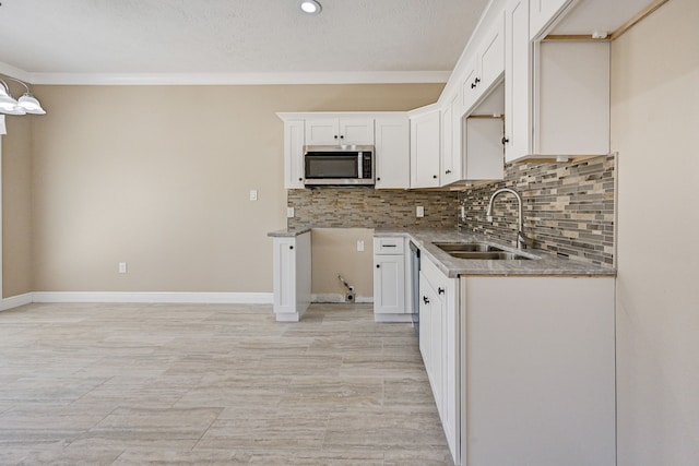 kitchen with tasteful backsplash, a sink, stainless steel appliances, recessed lighting, and white cabinetry