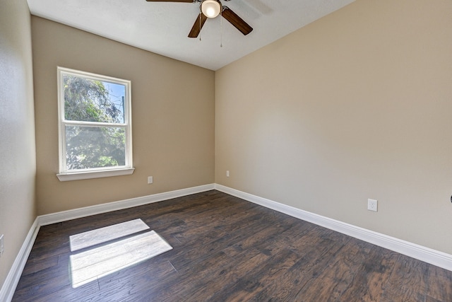 spare room featuring dark wood-style flooring, ceiling fan, and baseboards
