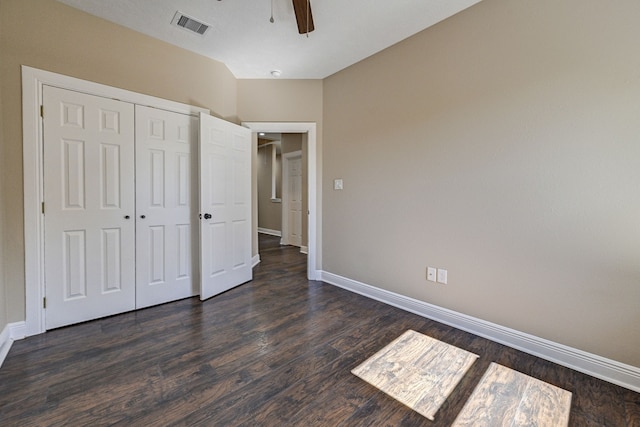 unfurnished bedroom featuring a closet, baseboards, visible vents, and dark wood-type flooring
