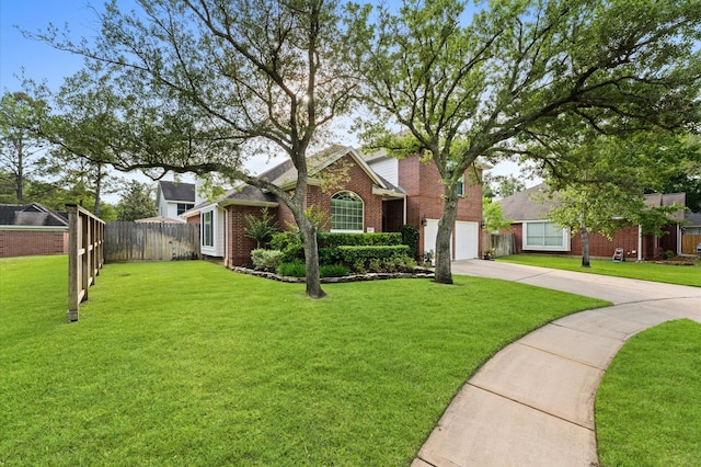 traditional home with fence, driveway, a front lawn, and brick siding