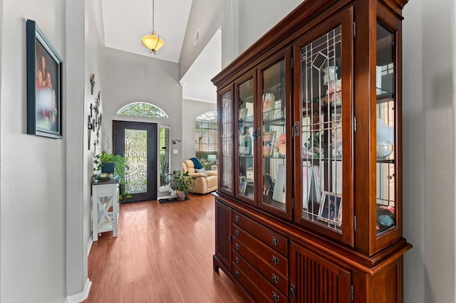 entryway featuring high vaulted ceiling, wood finished floors, and visible vents