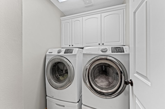 laundry room featuring visible vents, washer and clothes dryer, and cabinet space