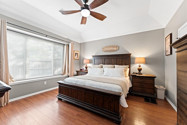 bedroom featuring baseboards, wood finished floors, and a tray ceiling