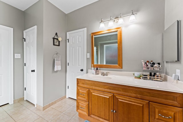 bathroom featuring tile patterned flooring, baseboards, and vanity