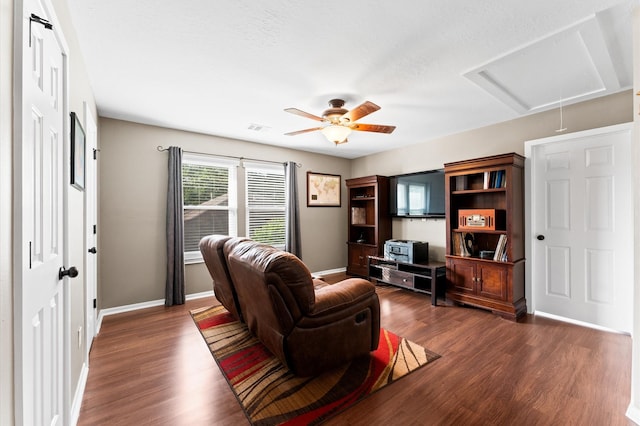 living area with visible vents, baseboards, attic access, a ceiling fan, and dark wood finished floors