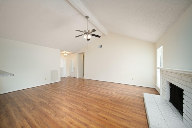 unfurnished living room with visible vents, ceiling fan, a fireplace, and light wood-type flooring