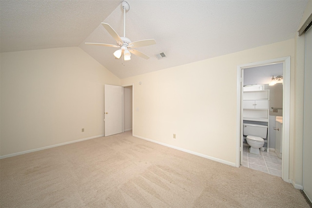 unfurnished bedroom with baseboards, light carpet, lofted ceiling, and visible vents