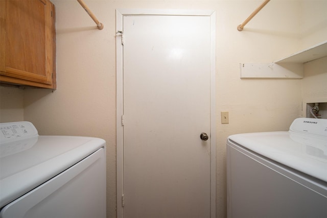 washroom featuring cabinet space and washing machine and clothes dryer