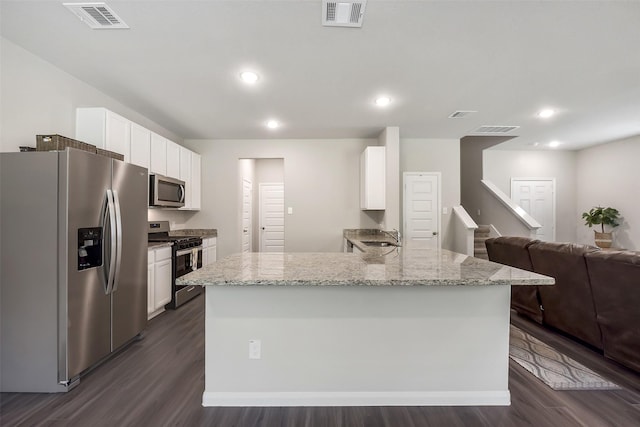 kitchen featuring visible vents, white cabinetry, and stainless steel appliances